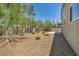 Spacious backyard featuring rock landscaping, mature trees, and a built-in barbecue area at 6815 Garden Grove Ave, Las Vegas, NV 89103
