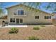 A spacious backyard with rock landscaping, patio, barbecue, and second-story balcony at 6815 Garden Grove Ave, Las Vegas, NV 89103