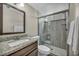 Well-lit bathroom features a granite countertop vanity and a walk-in shower with glass doors at 6815 Garden Grove Ave, Las Vegas, NV 89103