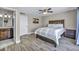 Cozy bedroom with wood-look flooring, ceiling fan, ensuite bathroom, and ample natural light at 6815 Garden Grove Ave, Las Vegas, NV 89103