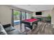 Well-lit game room with a pool table, modern fireplace, and outdoor access at 6815 Garden Grove Ave, Las Vegas, NV 89103