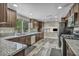 Well-lit kitchen featuring granite countertops and dark cabinets at 6815 Garden Grove Ave, Las Vegas, NV 89103