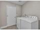 Functional laundry room with a white washer and dryer set and a door for easy access at 6815 Garden Grove Ave, Las Vegas, NV 89103