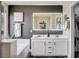 Bright double vanity bathroom with white cabinets, gray walls and framed mirror at 688 Monument Point St, Henderson, NV 89002