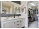 Bathroom with double vanity, large mirror and a walk-in closet for storage at 688 Monument Point St, Henderson, NV 89002