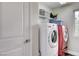 Bright laundry room featuring a washer and dryer, storage shelves and a window at 688 Monument Point St, Henderson, NV 89002
