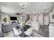Inviting open-concept living room with modern gray sectional and eat in kitchen with stainless appliances at 688 Monument Point St, Henderson, NV 89002