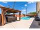 Relaxing backyard with in-ground pool, hot tub under gazebo, and covered seating area at 704 N Wallace Dr, Las Vegas, NV 89107