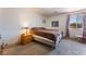 Comfortable bedroom featuring neutral carpet, a cozy bed, and a window with natural light at 704 N Wallace Dr, Las Vegas, NV 89107