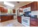 Functional kitchen space featuring ample cabinet storage, white appliances, and tiled flooring at 704 N Wallace Dr, Las Vegas, NV 89107