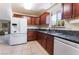 Cozy kitchen featuring dark wood cabinets, granite countertops and modern white appliances at 704 N Wallace Dr, Las Vegas, NV 89107