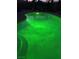 Backyard pool with green illumination at night at 704 N Wallace Dr, Las Vegas, NV 89107