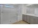 Modern bathroom features dual sinks, gray cabinetry, and a glass-enclosed shower with seating at 7086 Parkallen Ave, Las Vegas, NV 89113
