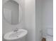 Bright bathroom features a pedestal sink, round mirror, and modern fixtures at 7086 Parkallen Ave, Las Vegas, NV 89113