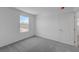 A bedroom with carpeted floors, plain walls, and a door with closet to the adjacent space at 7086 Parkallen Ave, Las Vegas, NV 89113