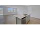 Bright, open kitchen featuring an island with sink, stainless steel dishwasher, and wood-style flooring at 7086 Parkallen Ave, Las Vegas, NV 89113