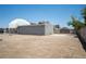 Expansive dirt backyard, showing the back of the home and dome, with a block fence offering privacy at 7215 Ullom Dr, Las Vegas, NV 89118