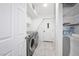 Clean laundry room with modern washer and dryer, storage cabinets, and organized shelving at 7215 Ullom Dr, Las Vegas, NV 89118