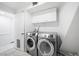 Bright and clean laundry room featuring modern washer and dryer units and functional white cabinets at 7215 Ullom Dr, Las Vegas, NV 89118