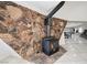 Living room with stone accent wall, wood-burning stove, and view of the dining area at 7215 Ullom Dr, Las Vegas, NV 89118