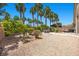 Backyard with gravel, patio furniture, a barbeque, palm trees and a block wall at 8021 Glacier Falls St, North Las Vegas, NV 89085