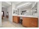 Spacious bathroom with dual sinks, vanity with stool, and expansive mirrors at 8021 Glacier Falls St, North Las Vegas, NV 89085