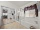 Bright bathroom with a glass shower and soaking tub under a window with decorative valance at 8021 Glacier Falls St, North Las Vegas, NV 89085