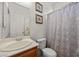 Well-lit bathroom features a vanity with sink, a toilet, and a shower with curtain at 8021 Glacier Falls St, North Las Vegas, NV 89085