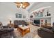 Comfortable living room with vaulted ceilings, cozy seating, and view of backyard through arched window at 8021 Glacier Falls St, North Las Vegas, NV 89085
