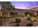 Backyard featuring a stone bench, gravel, and lush green landscaping against a block wall at 816 Stannard Ct, Henderson, NV 89052