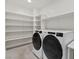 Bright laundry room with modern washer and dryer, and built-in shelving at 816 Stannard Ct, Henderson, NV 89052
