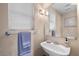 Bright bathroom featuring a pedestal sink, ample natural light, and modern fixtures, enhancing functionality at 8353 Lower Trailhead Ave, Las Vegas, NV 89113