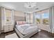 Bright main bedroom with a tufted headboard, two side tables, and lots of natural light at 8353 Lower Trailhead Ave, Las Vegas, NV 89113