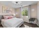 Light-filled main bedroom with a comfortable bed, a chair, and natural light from a large window at 8353 Lower Trailhead Ave, Las Vegas, NV 89113
