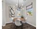 Cozy dining area with a round table, modern chandelier, and large windows with natural light at 8353 Lower Trailhead Ave, Las Vegas, NV 89113