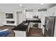 Modern kitchen with stainless steel appliances, granite countertops, and a view into the living room with fireplace at 8353 Lower Trailhead Ave, Las Vegas, NV 89113