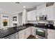 Stylish kitchen with stainless steel appliances, white cabinets, and a view of the electric fireplace at 8353 Lower Trailhead Ave, Las Vegas, NV 89113