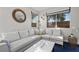 Comfortable living room with a white sectional sofa, stylish decor, and natural light streaming through the windows at 8353 Lower Trailhead Ave, Las Vegas, NV 89113