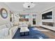 Bright living room with modern lighting, a fireplace, a large window, and a comfortable white sectional sofa at 8353 Lower Trailhead Ave, Las Vegas, NV 89113