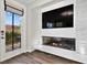A contemporary living space featuring a built-in fireplace, a large TV, and access to the outdoors at 8353 Lower Trailhead Ave, Las Vegas, NV 89113