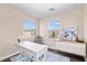 Well-lit home office with large windows, a white desk, and neutral decor at 8353 Lower Trailhead Ave, Las Vegas, NV 89113