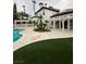 Backyard with pool, patio, landscaping, and mature palm trees at 8761 Rainbow Ridge Dr, Las Vegas, NV 89117
