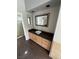 Clean bathroom with a vessel sink, dark countertops, and custom cabinetry, with a door leading to the shower at 8761 Rainbow Ridge Dr, Las Vegas, NV 89117