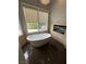 Modern bathroom featuring a luxurious soaking tub next to a fireplace with plenty of natural light at 8761 Rainbow Ridge Dr, Las Vegas, NV 89117