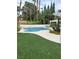 Backyard with pool, hot tub, patio, landscaping, and artificial grass at 8761 Rainbow Ridge Dr, Las Vegas, NV 89117