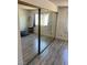 Bright bedroom featuring mirrored closet doors, light walls, and wood look flooring at 901 Sulphur Springs Ln # 101, Las Vegas, NV 89128