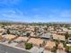 Wide aerial shot of a residential neighborhood featuring diverse homes with desert landscaping and city skyline at 920 Serpentina Ave, Las Vegas, NV 89123