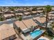 Aerial view featuring a private backyard oasis with pool, spa, and covered patio in desert neighborhood at 920 Serpentina Ave, Las Vegas, NV 89123