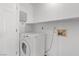 Laundry room with white washer/dryer, shelf, and utility hook-ups at 920 Serpentina Ave, Las Vegas, NV 89123