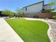 Community lawn featuring lush artificial turf, concrete walkway, rock features, and a seating bench at 9348 Wildcat Peak St, Las Vegas, NV 89178
